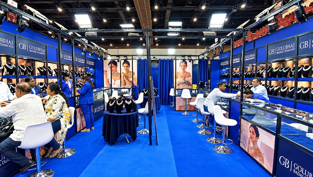 Jaya Media Golubhai Badalji Diamond trade exhibition booth with diamond jewelry showcases, overhead trusses, and consultation lounge